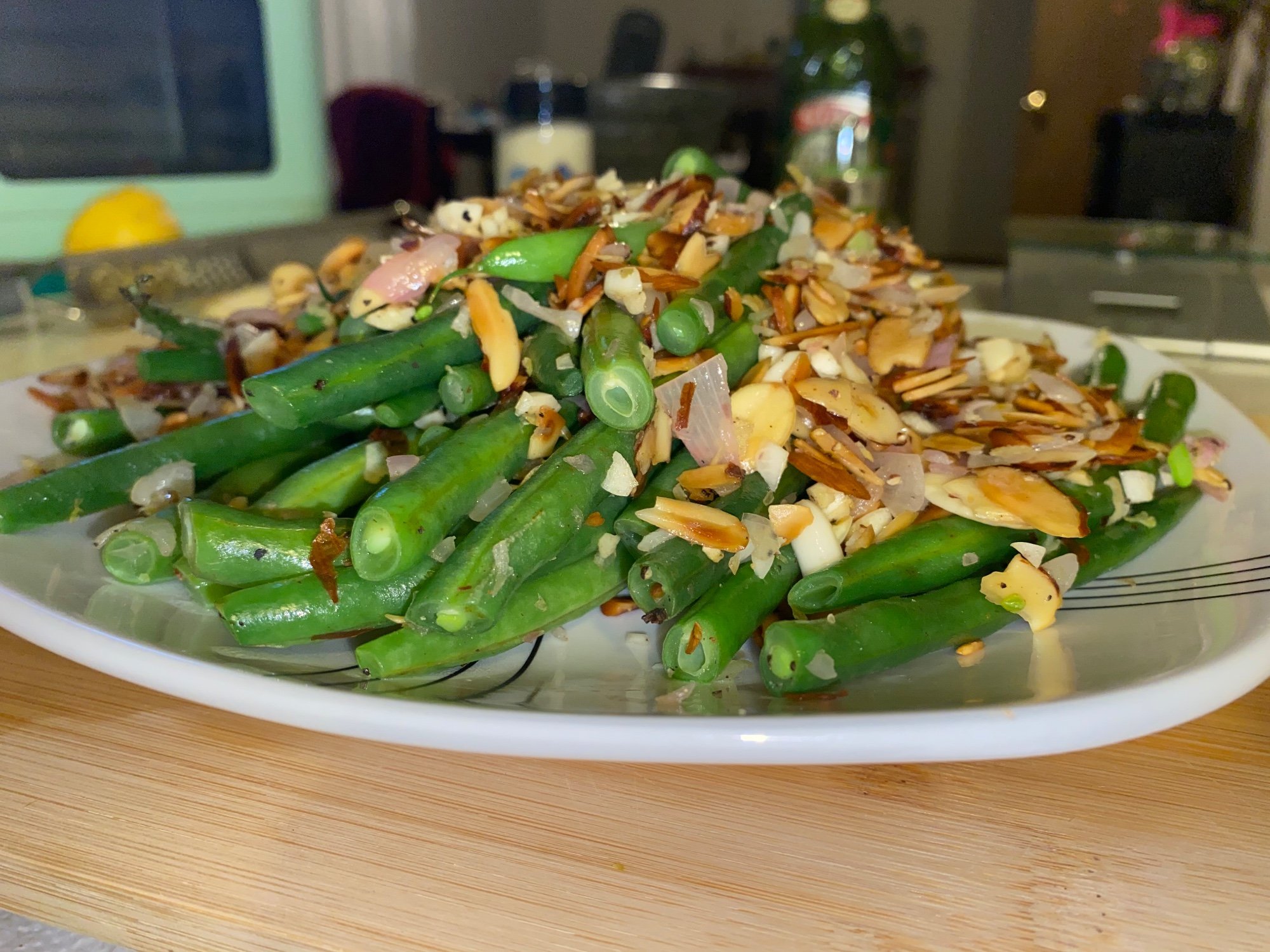 A platter of green beans topped with sliced almonds