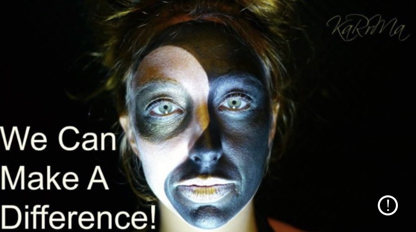 A face painted in black and silver, lit against a dark background, with the words We Can Make A Difference